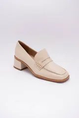 Mocasines clásicos de cuero color beige con taco cuadrado y detalle de antifaz.