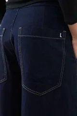 Pantalón de jean wide leg color azul oscuro con cintura alta y cinturón de cadena plateada.