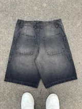 Short de jean negro con efecto lavado, corte a la rodilla y estampado con el logo de la marca en blanco en la pierna izquierda.