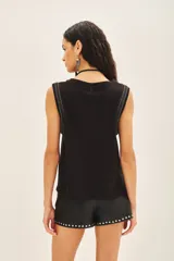 Musculosa de lino color negro con apliques de mostacillas y canutillos plateados en las sisas.