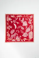 Pañuelo cuadrado rojo con estampado floral blanco y borde con diseño de puntos.