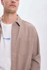 Sobrecamisa color tostado con cuello clásico, cierre frontal con botones, dos bolsillos de parche en el pecho y corte recto.