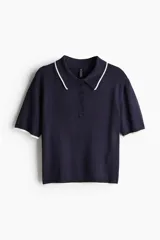 Remera polo azul marino de punto fino, corte entallado, con cuello clásico, tapeta de botones y mangas cortas con ribete blanco.