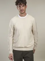 Sweater de punto color beige claro, de corte clásico y cuello redondo.