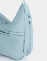 Cartera saca negra de tela deportiva con correa regulable, cierre superior y bolsillo frontal con cierre. Incluye charm lateral.