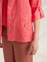 Camisa color coral de lino, corte holgado, escote redondo y mangas 3/4 ajustables con botón.