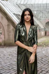 Vestido verde metalizado con escote en V pronunciado, mangas 3/4 y frunce en la cintura.