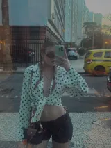 Camisa negra con estampado de lunares blancos, de manga larga y cuello clásico.