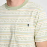Remera de manga corta con cuello redondo y bolsillo en el pecho. Diseño a rayas horizontales en tonos verde, beige y blanco con patrón geométrico.