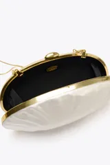 Bolso de mano rígido con forma ovalada irregular y efecto perlado. Tiene laterales metalizados, asa de cadena extraíble y cierre metálico.