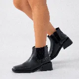 Bota corta negra de cuero con elástico lateral, caña de 12 cm y taco de madera de 4 cm.