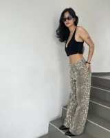 Pantalón de jean de tiro alto con estampado animal print en tonos marrones y blancos, de corte recto y holgado.