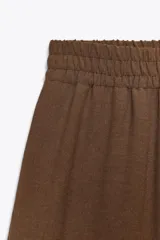 Pantalón marrón de tiro alto con cintura elástica y pierna ancha.