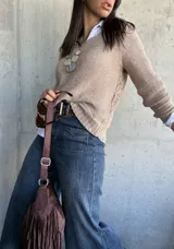 Sweater beige de hilo con cuello redondo y mangas largas.