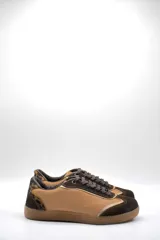 Zapatillas urbanas de cuero color beige con puntera y cordones marrones. Presentan un panel de animal print en el talón y suela de goma color caramelo.