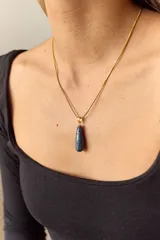 Collar dorado con cadena fina y dije colgante en forma de lágrima de piedra natural azul con vetas blancas.