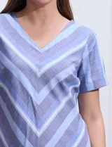 Vestido azul con estampado de líneas diagonales, escote en V y mangas cortas.