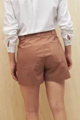 Short negro de gabardina, corte recto, con bolsillos delanteros y traseros, y presillas para cinturón.