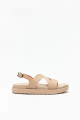 Sandalia color nude con tiras cruzadas y hebilla metálica ajustable.