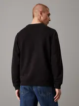 Buzo negro de felpa con cuello redondo y bordado de Calvin Klein en el pecho, confeccionado con mezcla de algodón y poliéster.