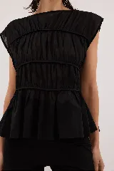 Blusa negra con escote redondo, sin mangas y detalle de frunces horizontales en el frente.