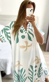 Túnica blanca con estampado de hojas y flores en verde agua y beige, con escote en V y mangas cortas.