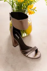 Sandalia de cuero vacuno color negro, con tiras finas en la parte delantera y pulsera ancha en el tobillo con cierre trasero. Taco ancho de 9 cm.