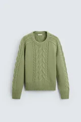 Sweater verde claro de punto con cuello redondo y mangas largas. Presenta diseño de trenzas en el centro y en las mangas.