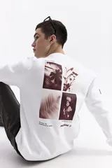 Buzo blanco de algodón con cuello redondo, puños y bolsillos laterales. Presenta un estampado en la espalda con cuatro imágenes de plantas en tonos sepia y texto.