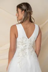 Vestido de fiesta blanco de tul con volados irregulares e incrustaciones de flores y hojas bordadas en hilo de seda en color blanco, crudo y dorado.