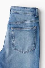 Pantalón de jean celeste de corte recto, tiro alto y cinco bolsillos.