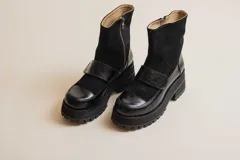 Botas negras de cuero con caña media, plataforma y hebilla decorativa.