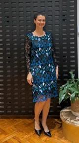 Vestido negro de manga larga, confeccionado en guipur bordado con flores azules y blancas.
