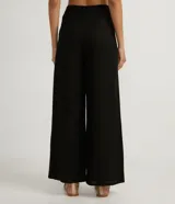 Pantalón wide leg negro de lino y viscosa, con cierre de botón y cremallera, trabillas y pliegues delanteros.