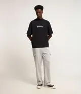 Pantalón baggy negro de algodón y poliéster, con cintura elástica ajustable con cordón, bolsillos laterales tipo cargo y bolsillo trasero.