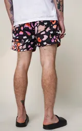 Short de baño negro con estampado abstracto en tonos naranja, lila y beige.