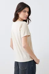 Remera color beige con lurex, de manga corta y corte recto.
