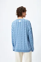 Sweater color beige con diseño de ochos en relieve, cuello redondo y corte oversize.