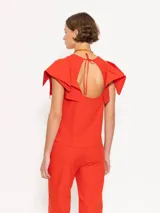 Top color naranja con cuello redondo y mangas cortas con volados.