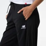 Pantalón negro de tiro alto con cintura elástica y cordón ajustable. Corte ancho con logo de New Balance en la cadera.