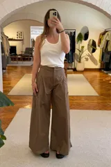 Pantalón marrón de corte ancho con pinzas en la cintura y bolsillos laterales.
