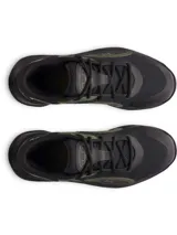 Zapatilla deportiva unisex Under Armour modelo UA Jet 25, color negro con detalles en verde oliva. Presenta una silueta de corte medio, capellada de malla transpirable y superposiciones sintéticas, mediasuela de amortiguación Micro G® y suela de goma con patrón de tracción multidireccional.