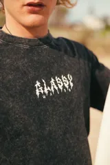 Remerón negro con efecto lavado y estampado en la espalda con la palabra "ALASSY" en letras amarillas con borde blanco, dentro de una forma geométrica.