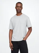 Remera gris de corte cropped, con cuello redondo y mangas cortas.