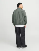 Campera bomber verde militar, de manga larga con cuello baseball y fit cómodo. Diseño con cierre frontal de cremallera, bolsillos delanteros funcionales y puños de canalé.