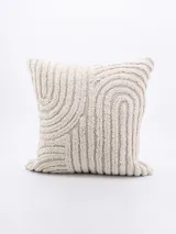 Funda de almohadón cuadrada color crema con textura en relieve formando un patrón de arcos concéntricos.