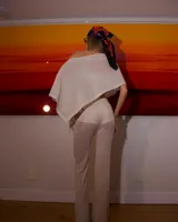 Pantalón largo de tejido ligero y traslúcido color beige claro, de corte acampanado.