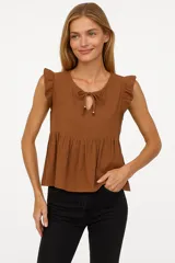 Blusa marrón de viscosa con cuello redondo con lazo, corte holgado y volados en los hombros.
