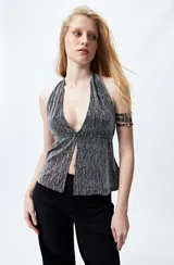 Top halter negro con escote profundo y destellos metalizados. El frunce frontal realza la silueta y el tajo sutil aporta un toque atrevido.