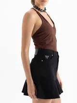 Minifalda de denim negro con cinco bolsillos tradicionales y un volado en el ruedo.